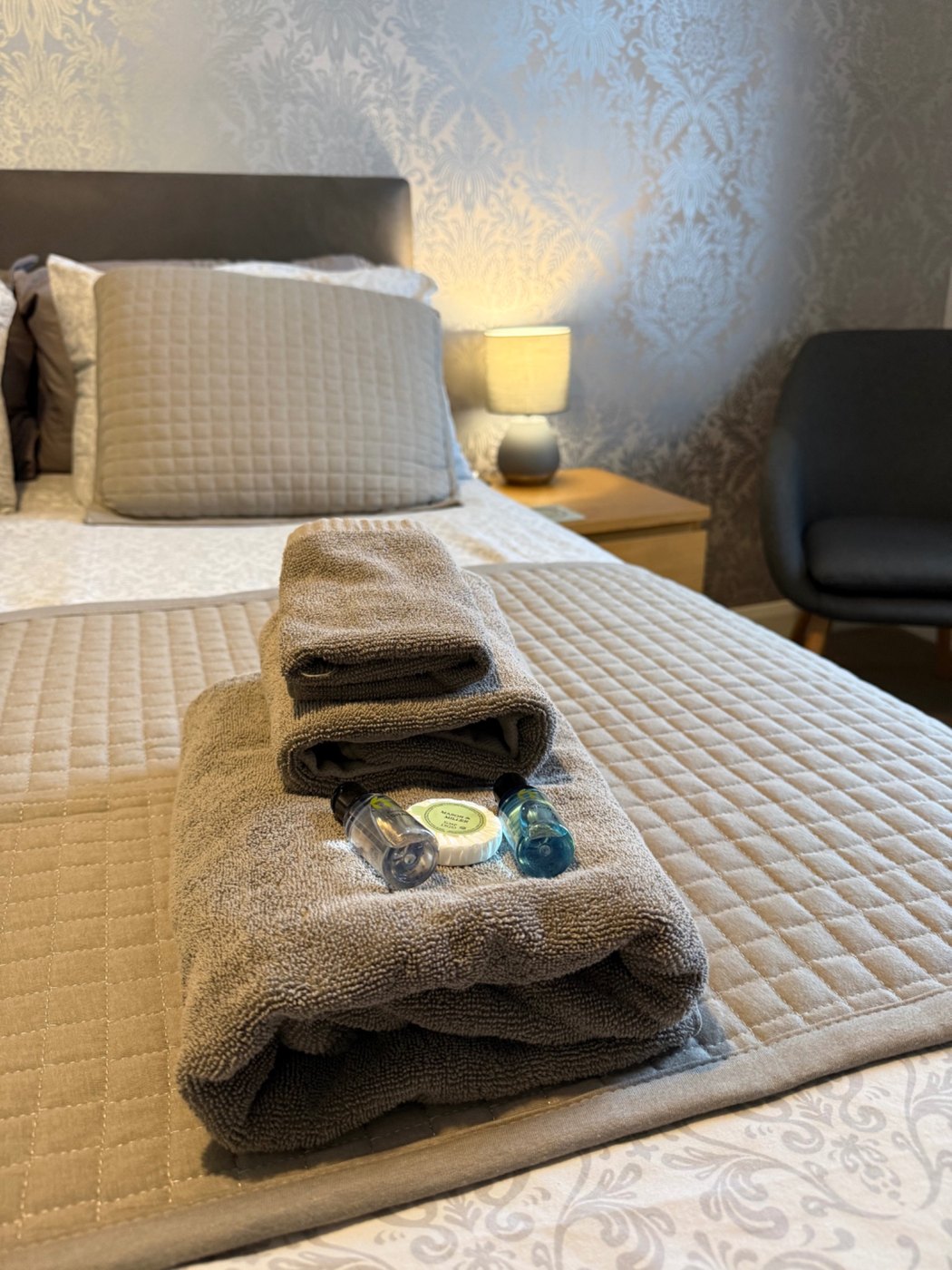 Fresh towels and toiletries arranged on a guest bed